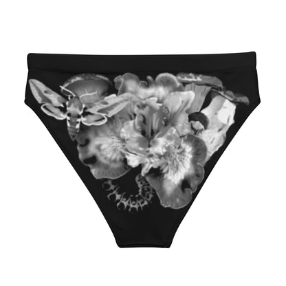 Monochromatic bikini bottom showcasing a flower in the center, surrounded by mushrooms. In it, a moth, cocoon, and caterpillar appear in a triad.